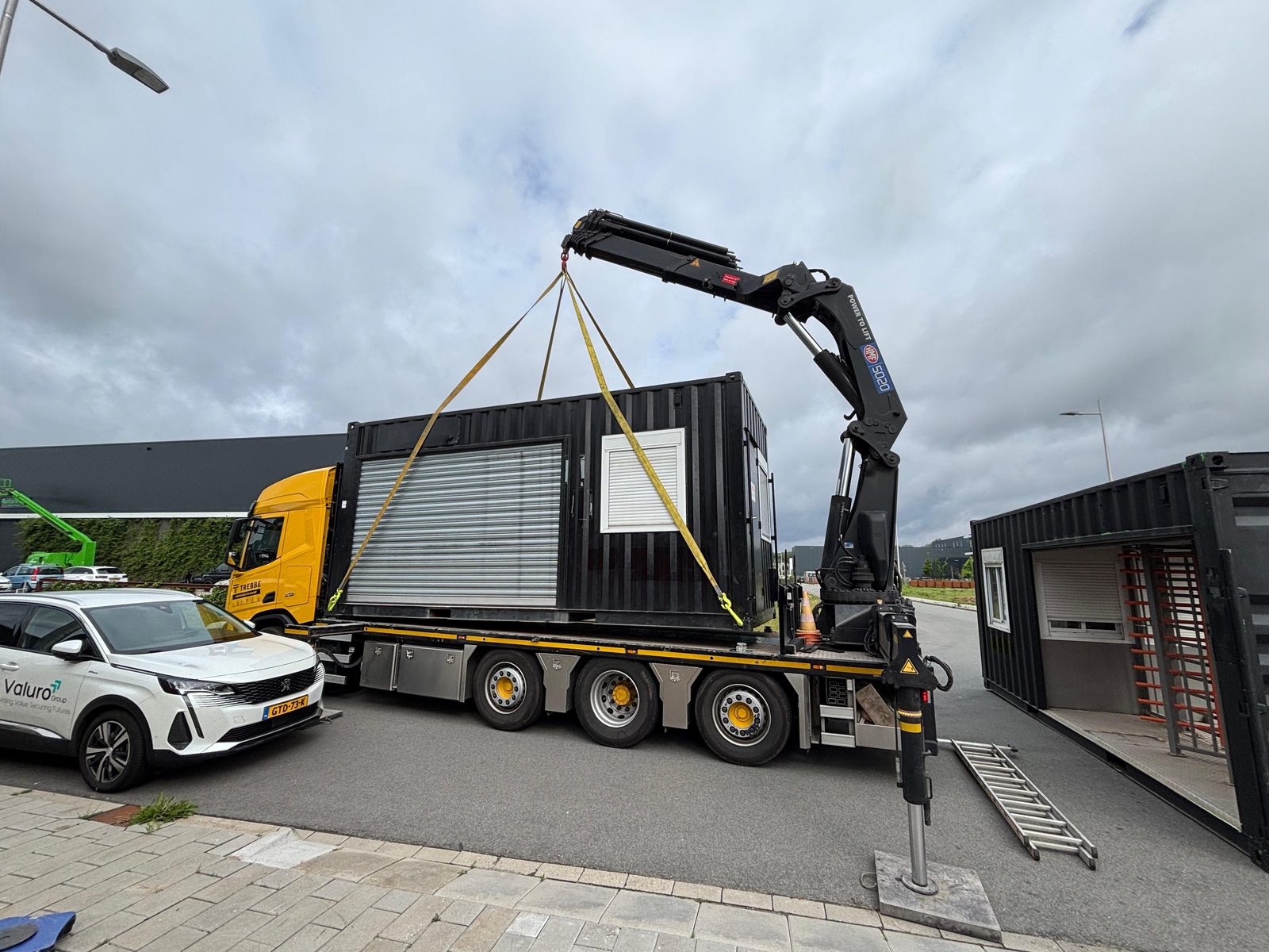 Unit met tourniquet en portiersruimte wordt met een kraan op locatie geplaatst